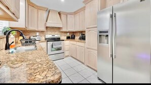 A kitchen with light wood cabinets, a granite countertop, stainless steel appliances, and a built-in oven. - Large  House in Peaceful McAllen. Large Pool, 10th/Trenton. Perfect Location (McAllen)