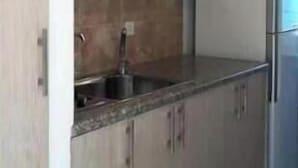 A modern kitchen with light wood cabinets, a granite countertop, and a stainless steel refrigerator. - Nonstop electricity 1 bedroom beachfront apartment & Seaview Family Duplex (Jabal Lubnan)