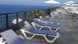 A terrace with sun loungers and umbrellas overlooking the sea. - Nonstop electricity 1 bedroom beachfront apartment & Seaview Family Duplex (Jabal Lubnan)