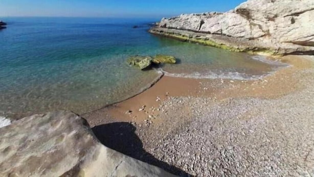 A coastal beach with clear water, rocky cliffs, and pebbly shore. - Nonstop electricity 1 bedroom beachfront apartment & Seaview Family Duplex (Jabal Lubnan)