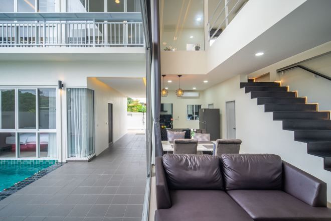 Een modern interieur met een zwembad, een trap en een zithoek.