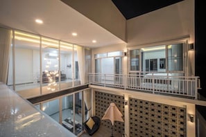 A modern interior with a glass balcony, a seating area, and a patterned wall. - La Lune Pool Villa Chiang Mai (Saraphi)