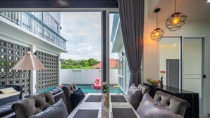 Un salon moderne avec une piscine, un espace salon extérieur et un balcon.