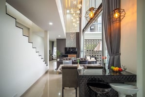 A modern interior with a staircase, a dining area, and a kitchen. - La Lune Pool Villa Chiang Mai (Saraphi)
