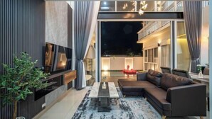 Un salon moderne avec un canapé d’angle, un téléviseur à écran plat et une table basse.