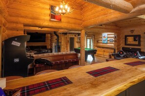 A wooden cabin interior with a bar area, seating, and a fireplace. - The Barn & The Log Cabin, Sleeps 12, 2 Hot Tubs (Oakenshaw)