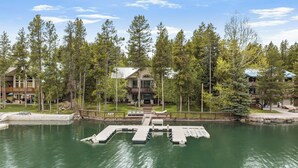 A lakeside lodge with a dock, a pool, and a large building with multiple balconies.