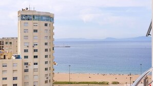 A high-rise building with a view of a beach and the sea.