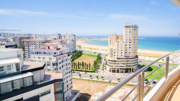 A high-rise building with a view of a beach and ocean.