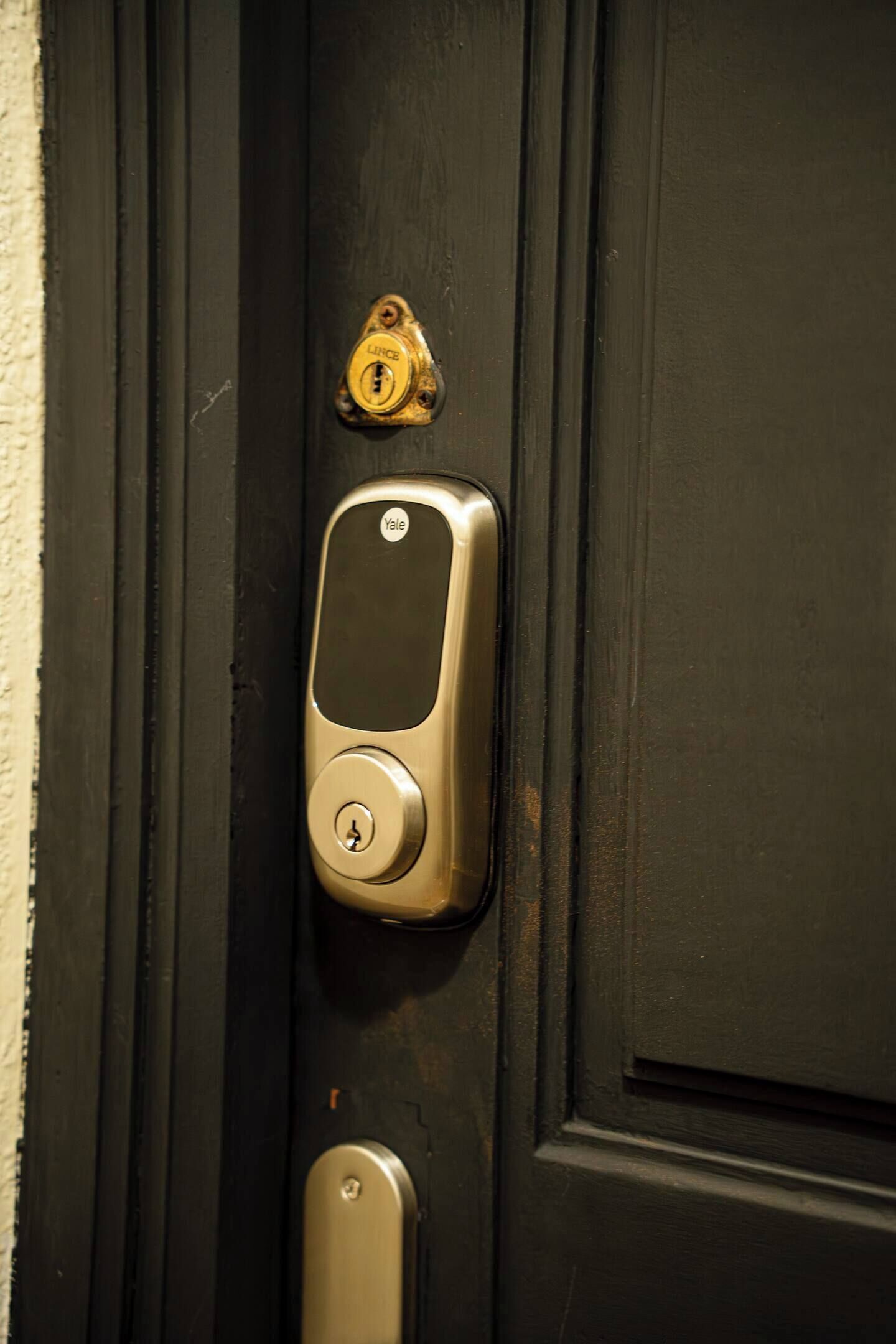 Una cerradura inteligente Yale instalada en una puerta negra.