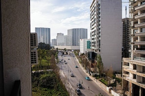 Un paisaje urbano con modernos rascacielos, una calle concurrida y un paseo peatonal.