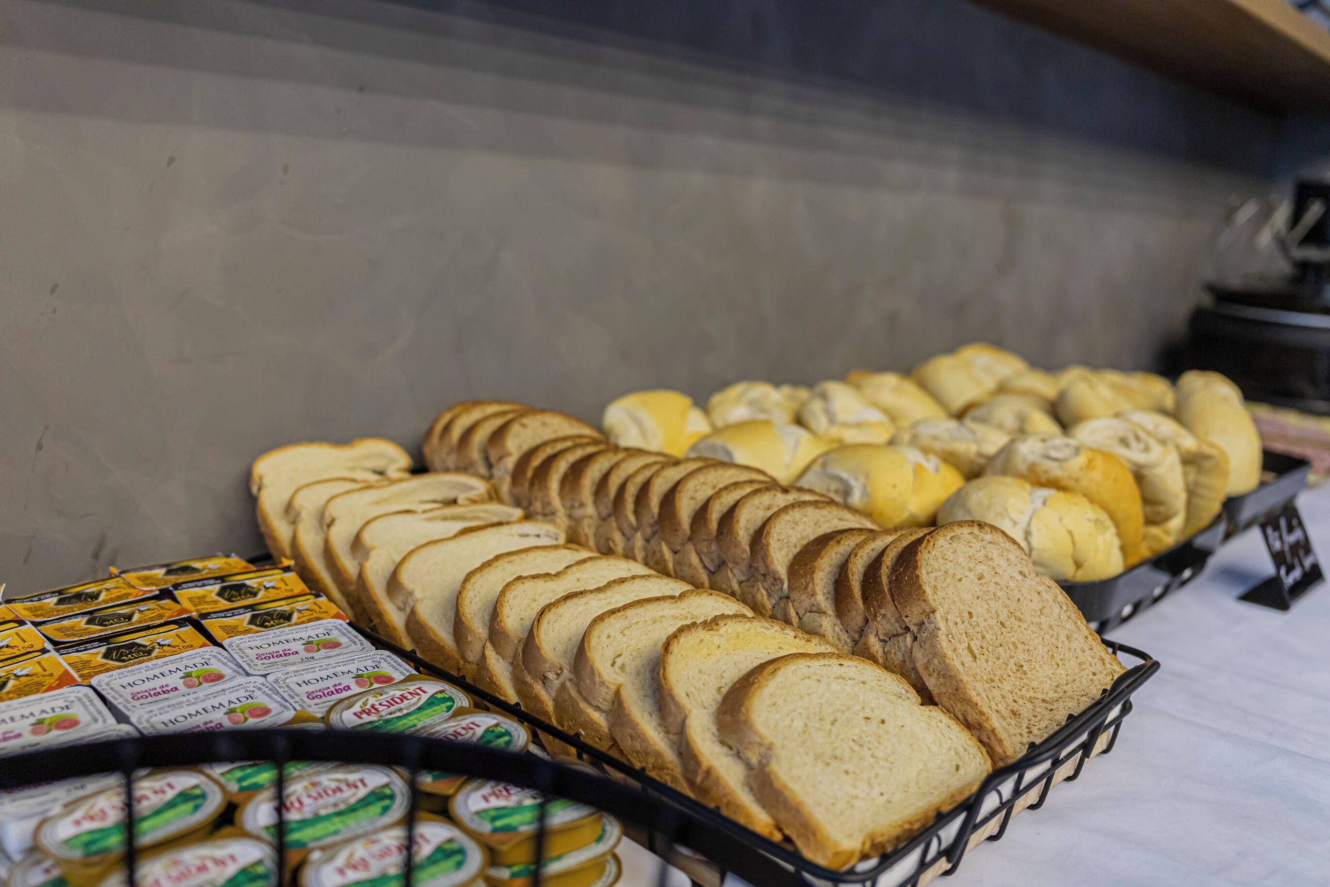 Vers gesneden brood en verpakte sauzen op een tafel.