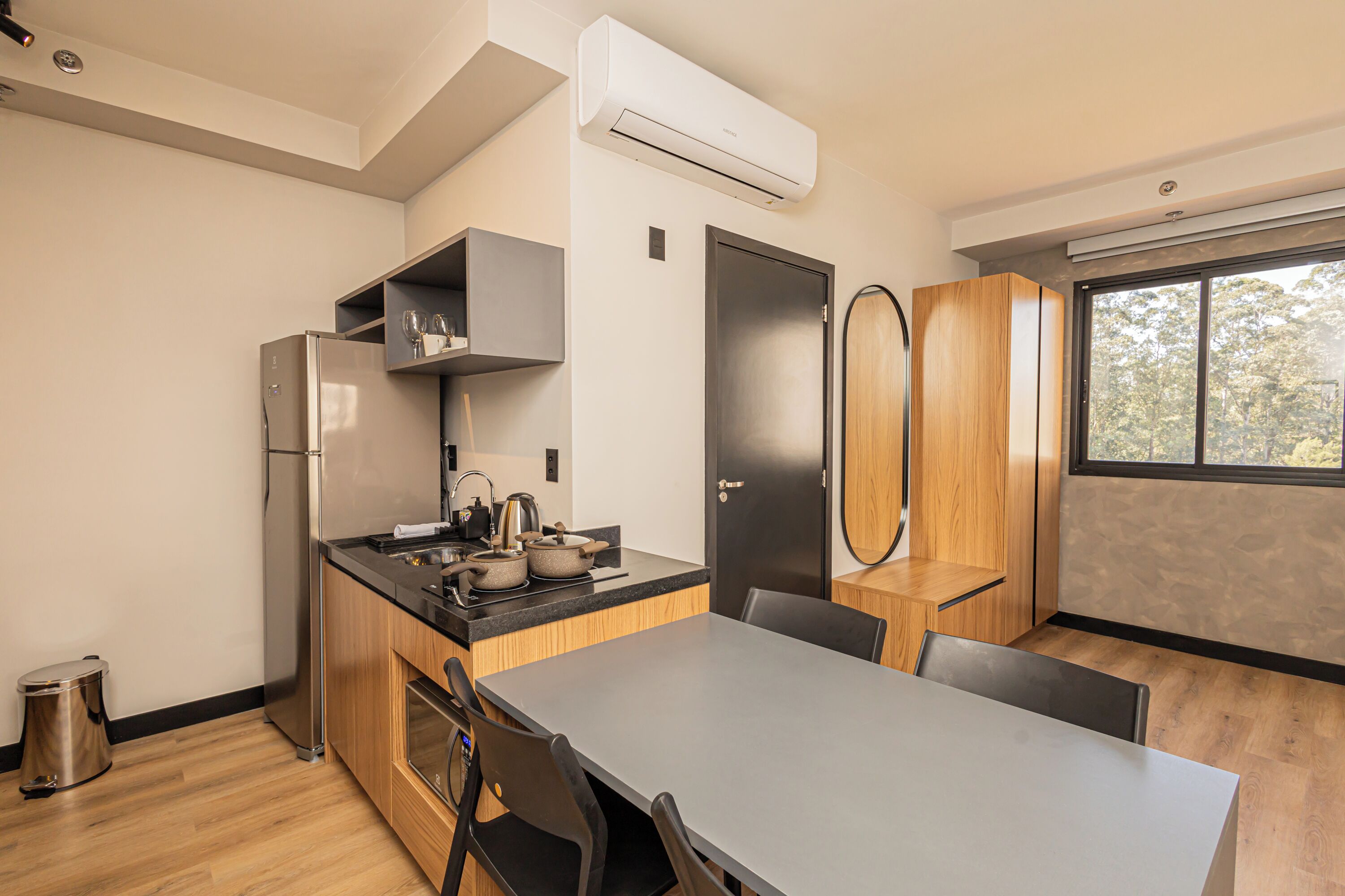 A modern kitchen with a built-in stove, a stainless steel refrigerator, and wooden cabinets.