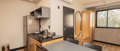 A modern kitchen with a built-in stove, a stainless steel refrigerator, and wooden cabinets.