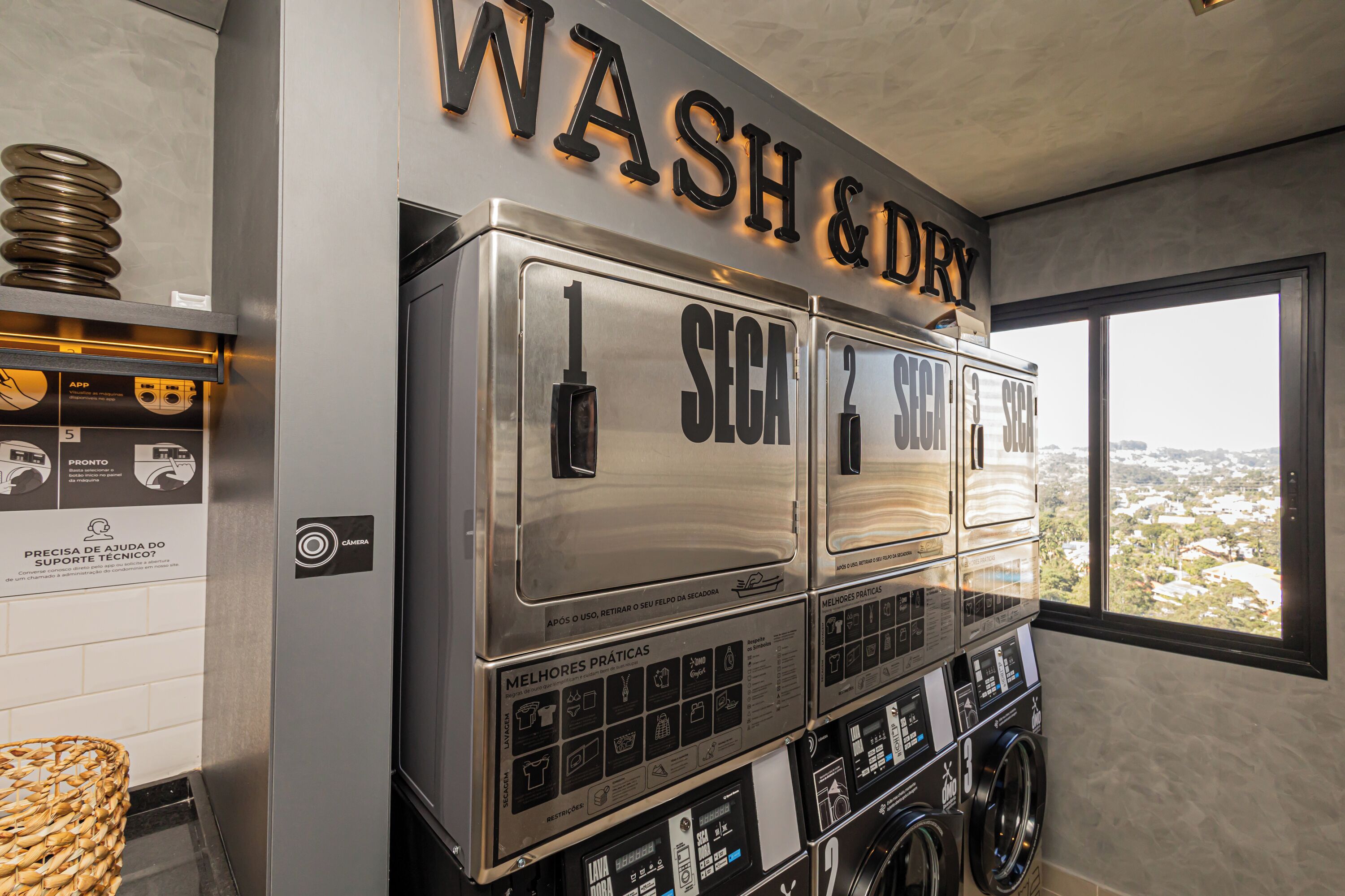 A commercial laundry area with three stacked machines labeled "SECA" and a "WASH & DRY" sign above.