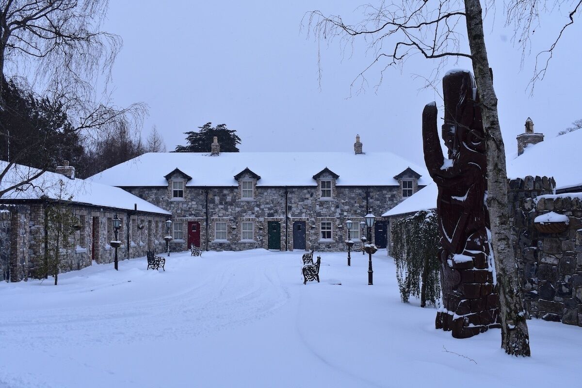 A stone building with multiple windows and a snow-covered roof.