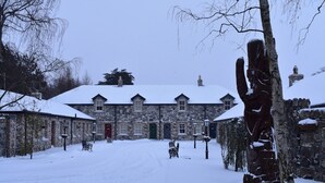 Un edificio de piedra con techo cubierto de nieve y varias ventanas.