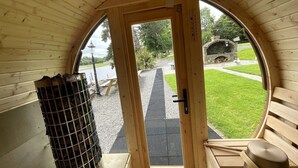 Interior de madera con una puerta circular que da al exterior.