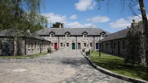 A stone building with a central entrance and multiple doors.