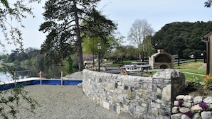 A stone wall with a stone oven, a dock, and a calm lake.