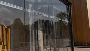 Un edificio moderno con fachada de vidrio, con la etiqueta "STONEHOUSE Apt. 1-4".