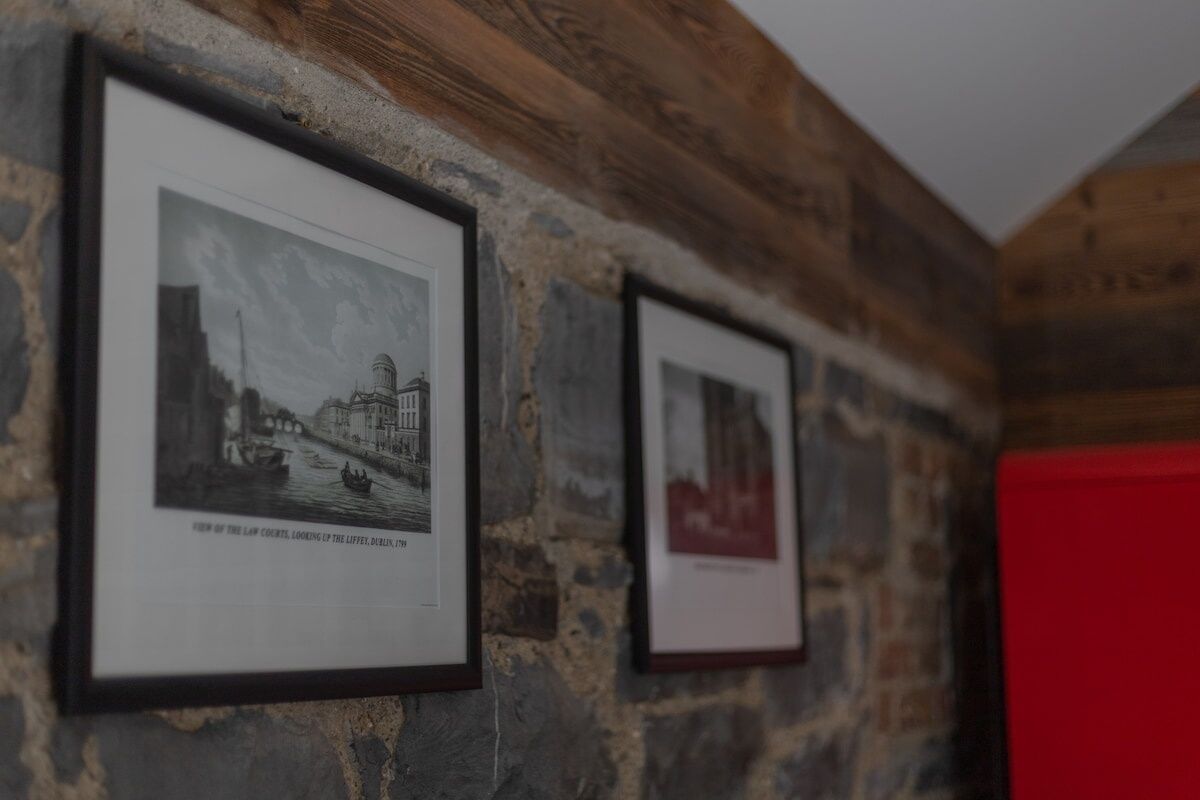 Framed black and white photographs on a stone wall.
