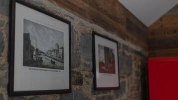 Framed black and white photographs on a stone wall.