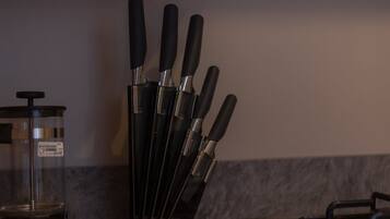 A kitchen counter with a knife block holding several knives.