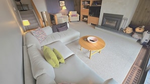 Ein modernes Wohnzimmer mit Sofa, Couchtisch und Kamin.