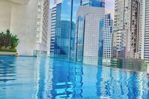 Una piscina con reflejos de edificios altos circundantes.
