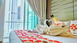 A hotel room with a bed, a window with curtains, and a view of high-rise buildings. - Lila Suite One Bukit Ceylon (Kuala Lumpur)