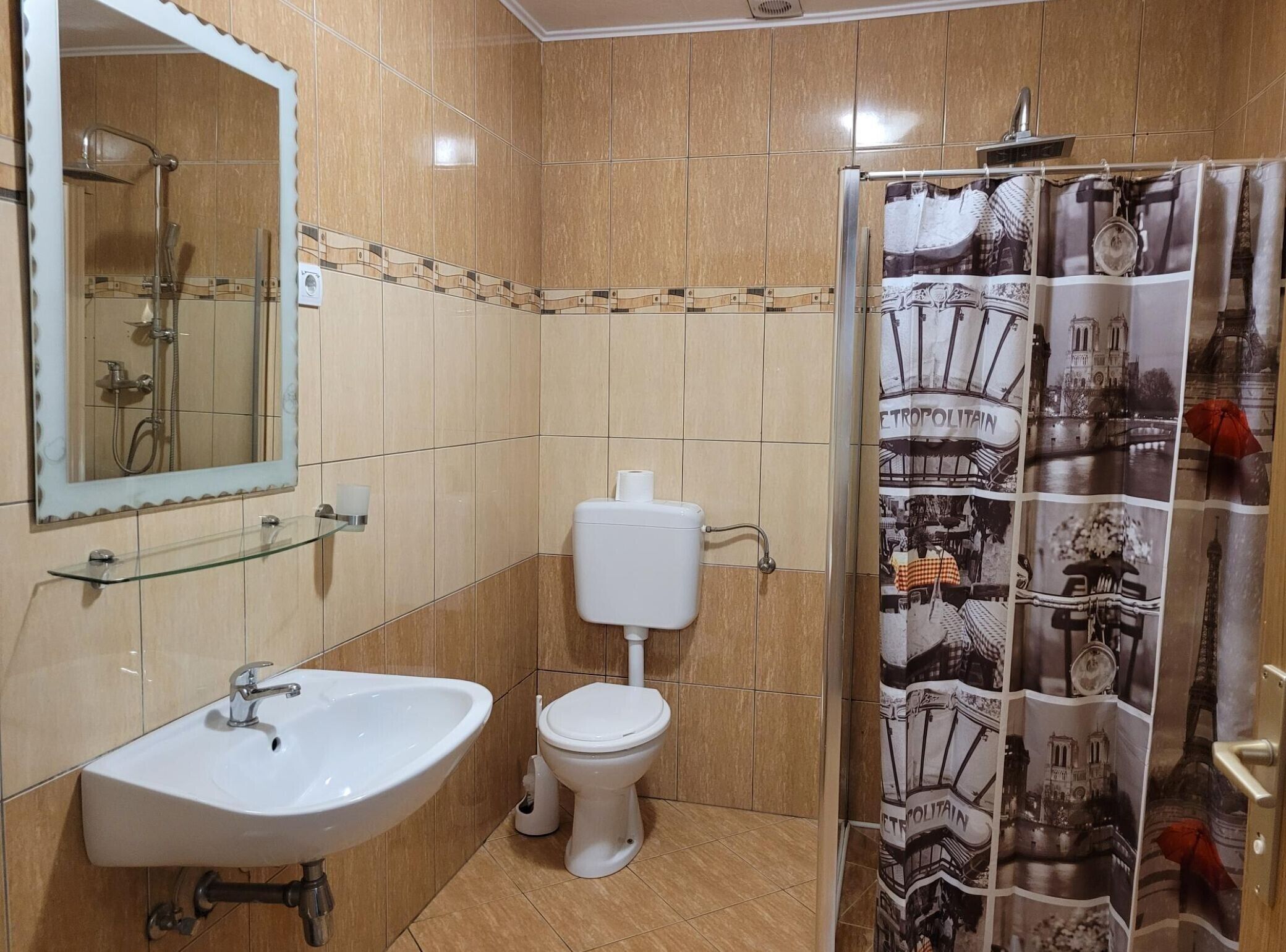 Un baño con lavamanos, inodoro y ducha.