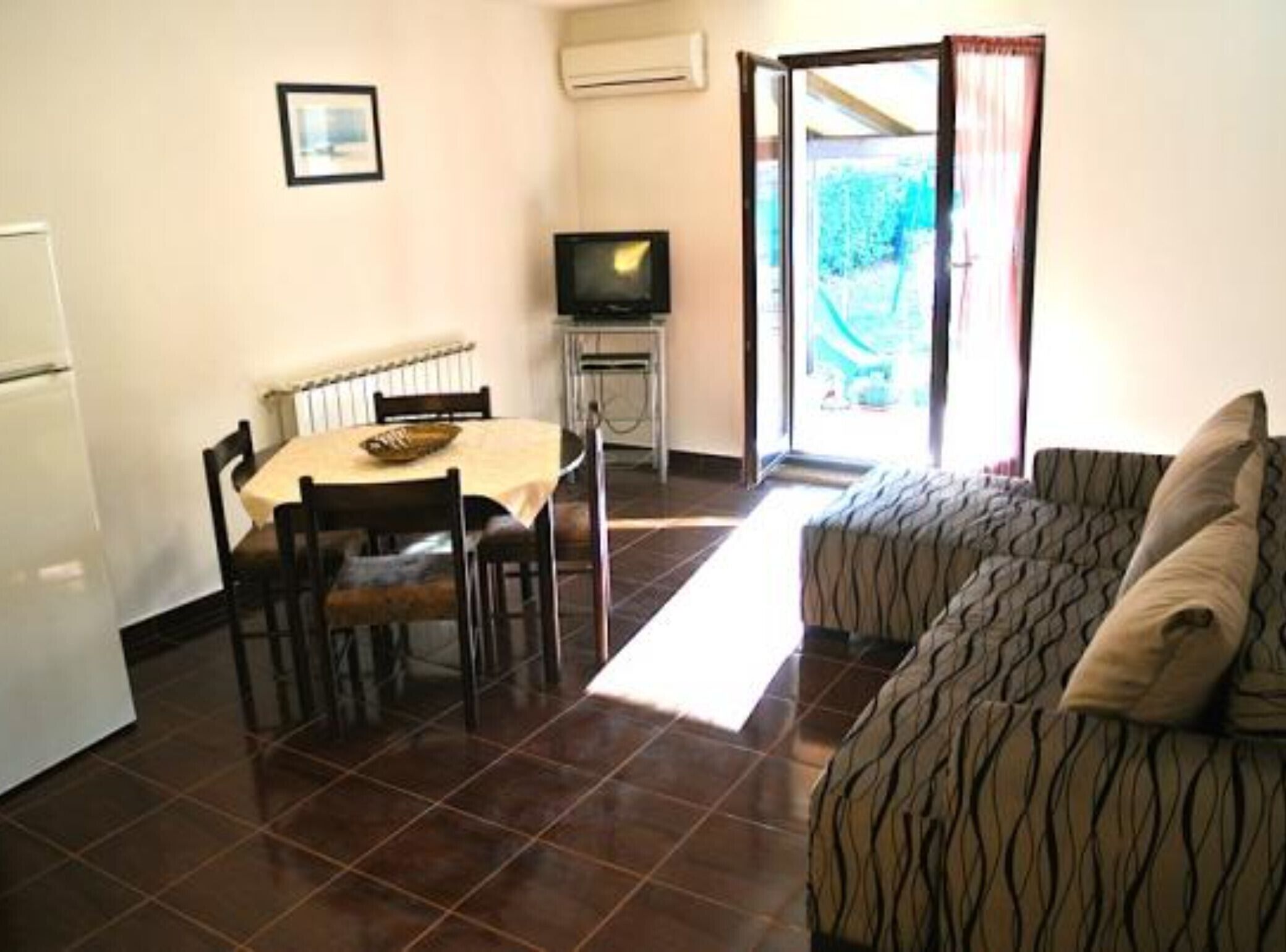 A compact living space with a dining area, a television, and a sofa.