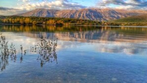 A calm lake with mountains in the background and a clear sky. - Apartment and Room Mare Vrlika - Double Bedroom with Terrace and External Kitchenette (Sinj)