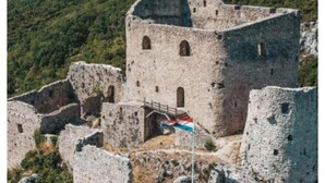 A stone castle with a flagpole, surrounded by forested hills. - Apartment and Room Mare Vrlika - Double Bedroom with Terrace and External Kitchenette (Sinj)