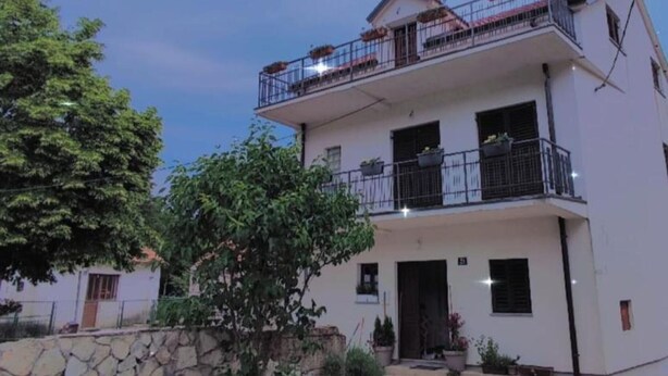 A two-story building with balconies, a stone wall, and potted plants. - Apartment and Room Mare Vrlika - Double Bedroom with Terrace and External Kitchenette (Sinj)