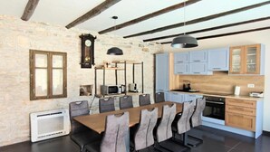 A modern kitchen with a wooden countertop, a microwave, and a stove. - Villa Galant with Pool & Sauna Maružini (Kanfanar)