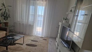 A living room with a sofa, coffee table, TV, and decorative items. - Apartments Bilić Trogir - Three-Bedroom Apartment With Sea View (A2) (Trogir)