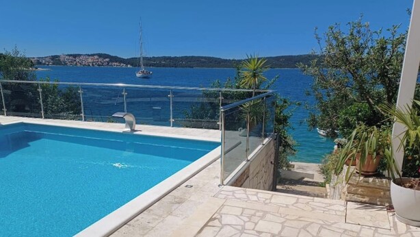 A swimming pool with a clear view of the sea and a sailboat in the distance. - Apartments Bilić Trogir - Three- Bedroom Apartment With Sea View (A3) (Trogir)