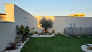 A rooftop garden with artificial grass, a large tree, and a solar panel array. - M4ree Seaside Suite And Relax (Bari)