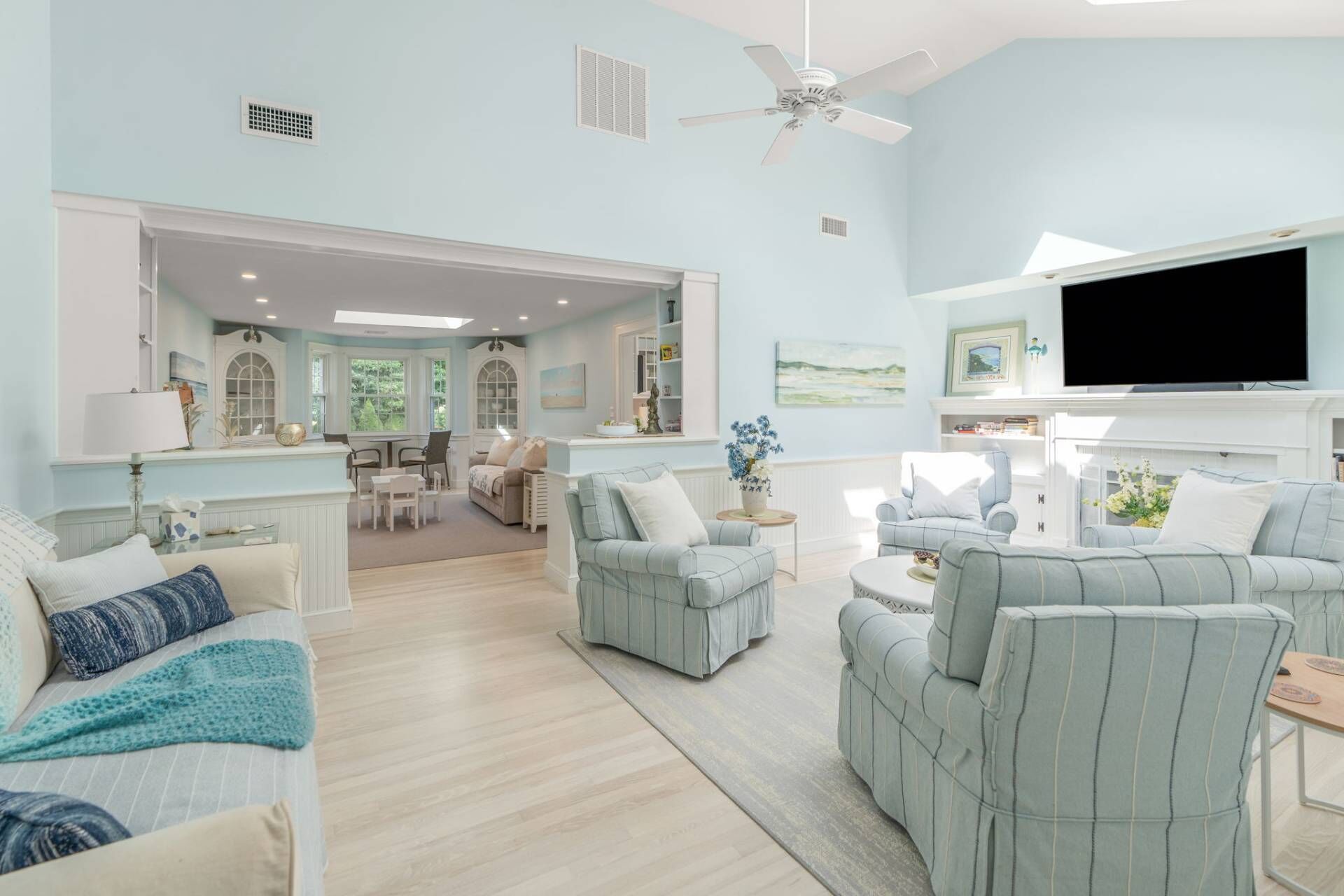 A spacious living room with a large TV, comfortable seating, and a view of the outdoors.