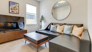 Een moderne woonkamer met een bank, salontafel en een flatscreen televisie.