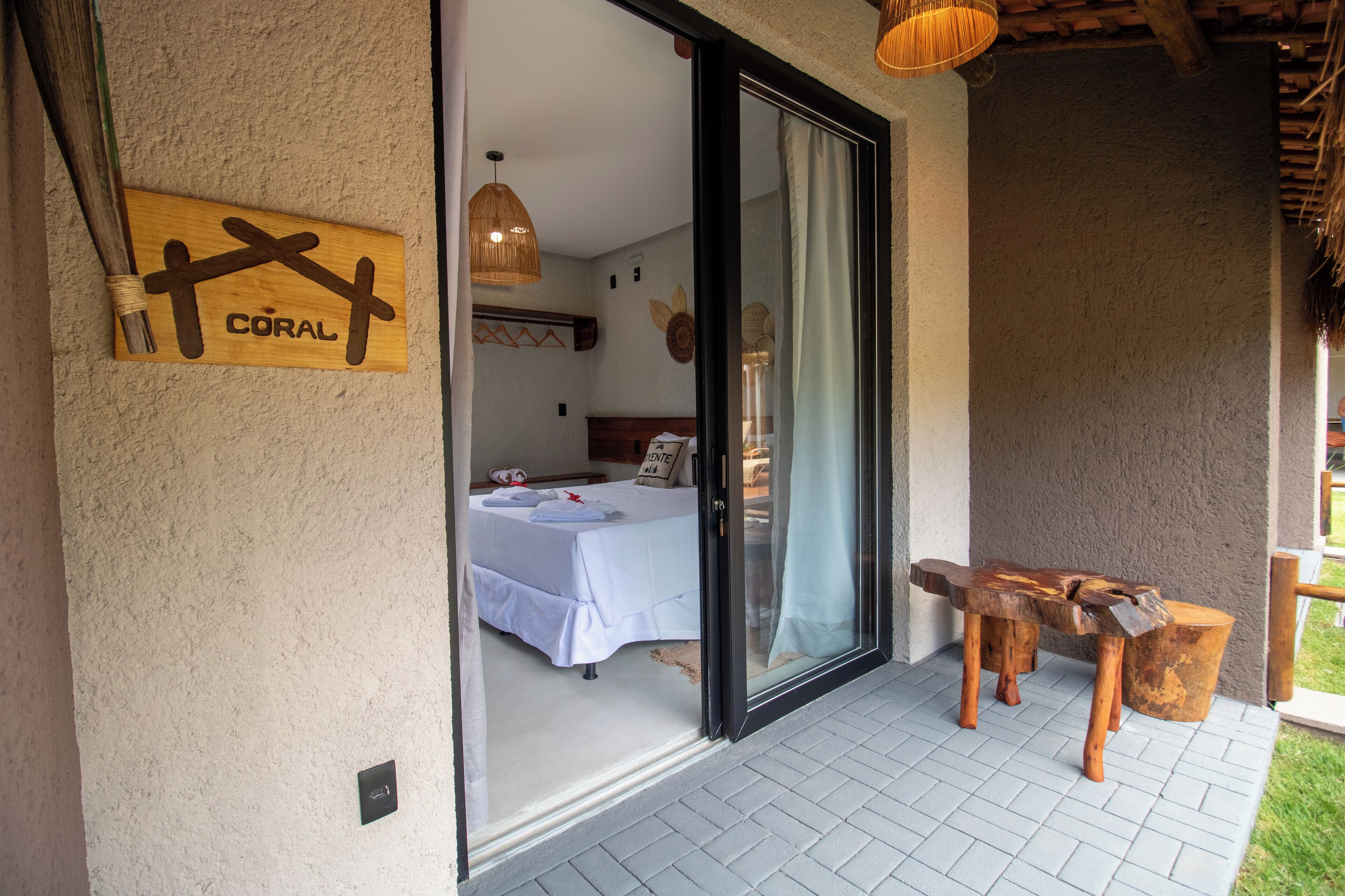 Una habitación con una cama, una mesa y un letrero con una cruz y la palabra 'CORAL'.