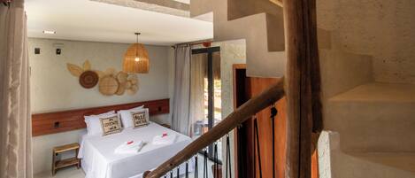 Un dormitorio con cama, cabecera de madera, lámpara colgante y vistas al exterior.