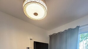 A room with a bar area, a television mounted on the wall, and a window with curtains. - Charming 1-bedroom studio facing the pool, in the heart of Sosua (Sosúa)