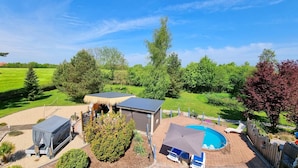 A backyard with a swimming pool, a covered outdoor seating area, and a shed. - Koppelkuck vacation apartment on a beautiful vacation farm with pool and sauna Ostseena (Schwartbuck)