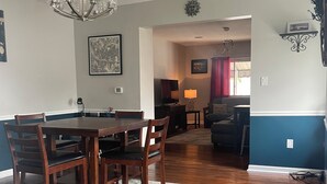 A dining area with a wooden table and chairs, a chandelier, and a rug. - Cozy, spacious 1 bdrm apt in Bloomfield with off street parking. Great location! (Pittsburgh)