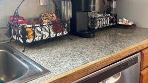 A kitchen with wooden cabinets, a stainless steel dishwasher, a coffee maker, and a kettle. - Cozy, spacious 1 bdrm apt in Bloomfield with off street parking. Great location! (Pittsburgh)