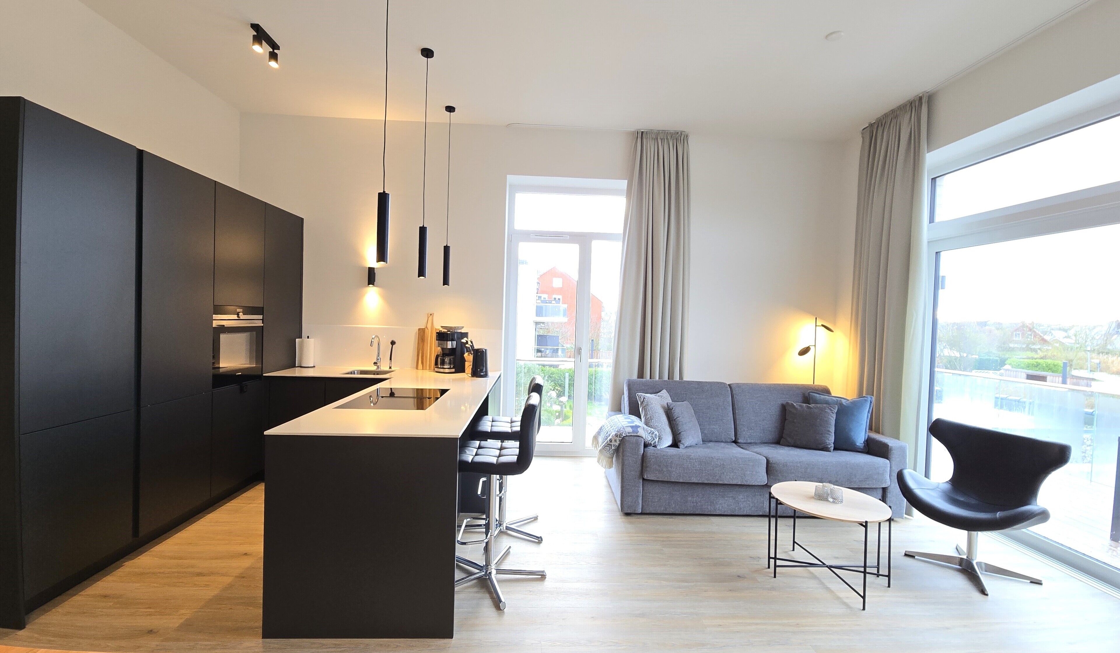 Eine moderne Wohnung mit Küche, Essbereich und Wohnzimmer.
