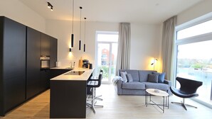 Un apartament modern amb cuina, zona de menjador i saló.